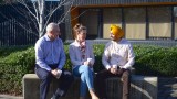 Mental health nurse sitting on a bench outside having coffee with two clients