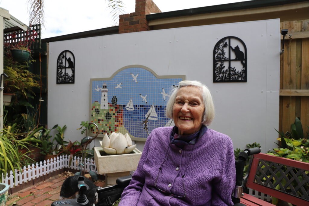 Florence Gibbs at home in the garden with one of her mosaic masterpieces