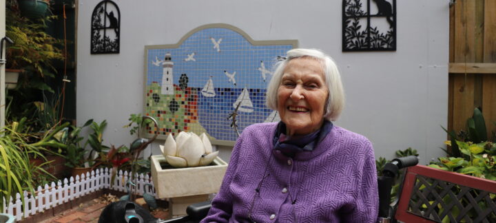 Florence Gibbs at home in the garden with one of her mosaic masterpieces